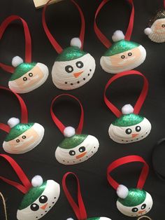 snowman ornaments are hanging from red ribbon