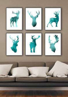 four green deer silhouettes mounted on the wall above a couch