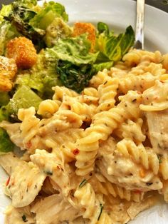 a white plate topped with pasta and salad