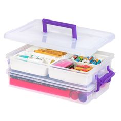 a plastic storage box filled with lots of crafting supplies on top of a white surface