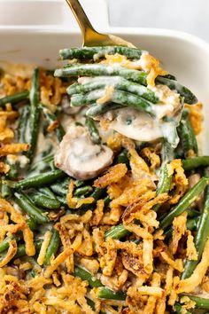 green bean casserole with mushrooms and cream sauce in a white dish on a table