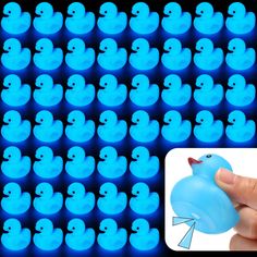 a hand holding a blue rubber duck in front of an image of rows of ducks