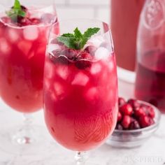 two glasses filled with cranberry punch and garnished with mint