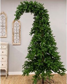 a small christmas tree sitting on top of a wooden table next to a white dresser