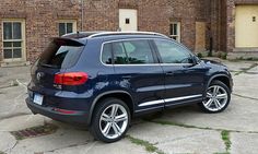 a blue volkswagen suv parked in front of a brick building