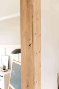 a tall wooden pole sitting in the middle of a living room next to a computer desk