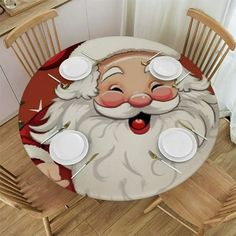 a table with a santa claus face on it and white plates around it, along with wooden chairs