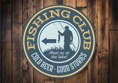 the fishing club sign is mounted on a wooden wall with an arrow pointing to it