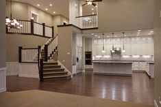 a large open floor plan with stairs leading up to the kitchen