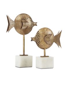 two gold fish sculptures sitting on top of each other in front of a white background