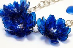 two blue flowers are attached to silver chains