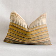 a striped pillow sitting on top of a white surface