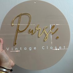 a close up of a person holding a sign that says purse vintage closet on it