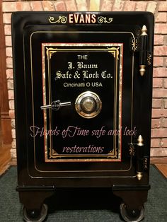 a black and gold safe sitting in front of a brick wall