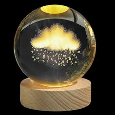 a glass ball with an image of a cloud in the sky inside it on a wooden stand