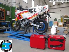 the motorcycle is being worked on in the shop with some tools and cases around it