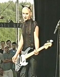 a woman standing in front of a microphone holding a guitar