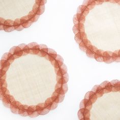 four orange and white plates with ruffled edges on a white tablecloth background, arranged in the shape of three circles