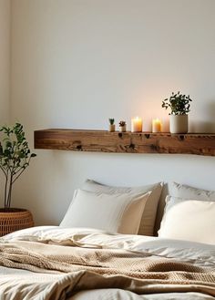 a bed with white sheets and pillows next to a wooden shelf above the headboard