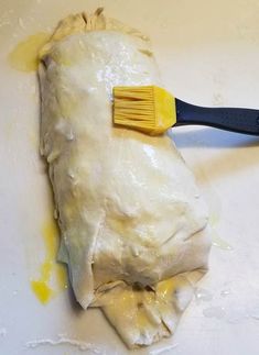 a spatula is used to brush the dough off with yellow paint on it's surface