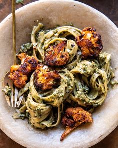 pasta with chicken and pesto sauce in a bowl