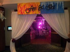 an entrance to a party with white drapes and purple lights on the sidelines