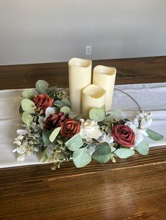 three candles are sitting on a table with flowers