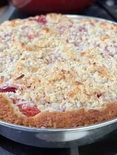 a pie sitting on top of a pan covered in toppings and crumbs