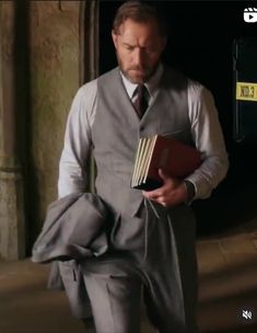 a man in a suit and tie holding a book