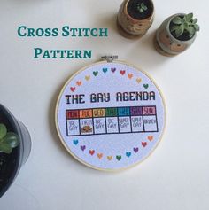 cross stitch pattern with the gay agenda written on it and potted succulents