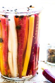 a jar filled with pickled vegetables sitting on top of a table