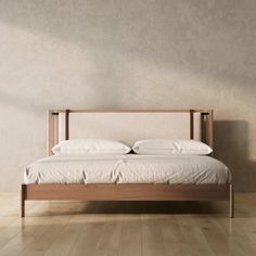 a bed sitting on top of a hard wood floor next to a white wall in a bedroom