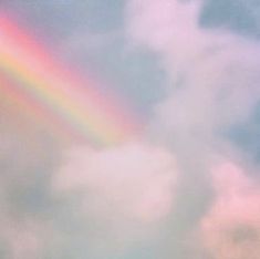 a rainbow in the sky with clouds above it