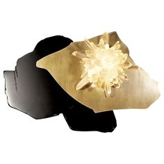 two pieces of gold and black metal with a flower on it