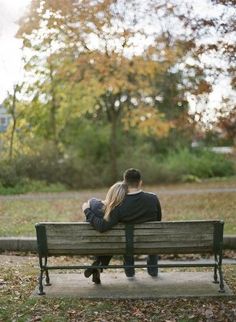 a man and woman sitting on a park bench