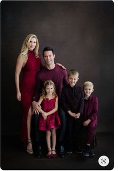 a family posing for a photo in front of a black background