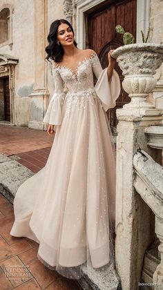 a woman in a wedding dress leaning against a wall