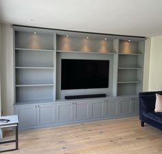 a living room filled with furniture and a flat screen tv on top of a wall