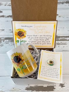 an open box containing two sunflowers and a note with a ring on it