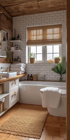 a bathroom with white walls and wooden floors is pictured in this image, there are towels on the bathtub next to the tub