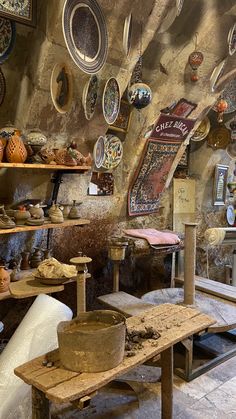 an old fashioned pottery shop with lots of plates on the wall