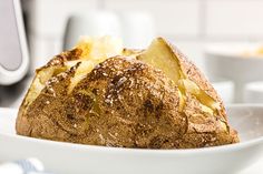 a loaf of bread sitting on top of a white plate in front of a microwave