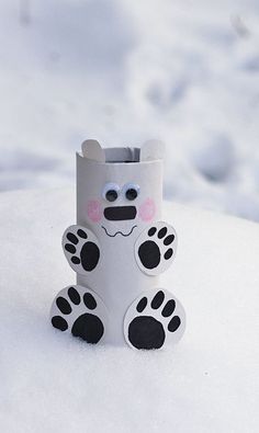 a white paper tube with black and pink paw prints on it sitting in the snow