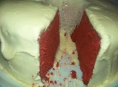 a red velvet cake with white frosting and sprinkles