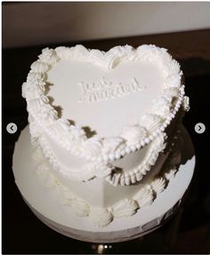 a white heart shaped cake sitting on top of a table