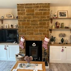 a living room filled with furniture and a fire place in front of a tv mounted on a wall