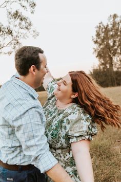 a man and woman standing next to each other in a field