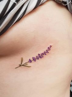 a woman's stomach with purple flowers on the side and one flower in the middle