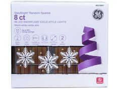 the box has snowflakes on it and purple ribbons in front of each other