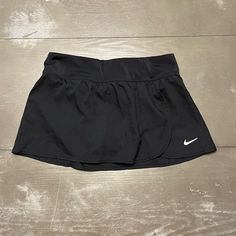 Nike Black Tennis Skirt Lined With Bloomer (Not Shorts). White Nike Logo (Reflective?) On Bottom Left Of Skirt. Overlap Pleat/Wrap Style On Left. Slightly Stretch Banded Waist. Zippered Pocket On Upper Right Of Back Bank. Bought New And Never Worn. Size Small Measures 13.5 Inches Across Waist 20 Inches At Bottom Across At Widest Point 11 Inches Top To Bottom In Front In Middle, 11.5 Inches In Back Material 109% Polyester Trimmings 80% Polyamide, 20% Elastane Lining 100% Polyester Mesh 75% Polyam Nike Stretch Lined Skirt Bottoms, Nike Stretch Lined Skirt, Black Mini Skirt For Sports, Spring Season, Nike Tennis Skirt, Nike Skirt, Nike Skirts, Black Tennis Skirt, Tennis Skort, Purple Skirt